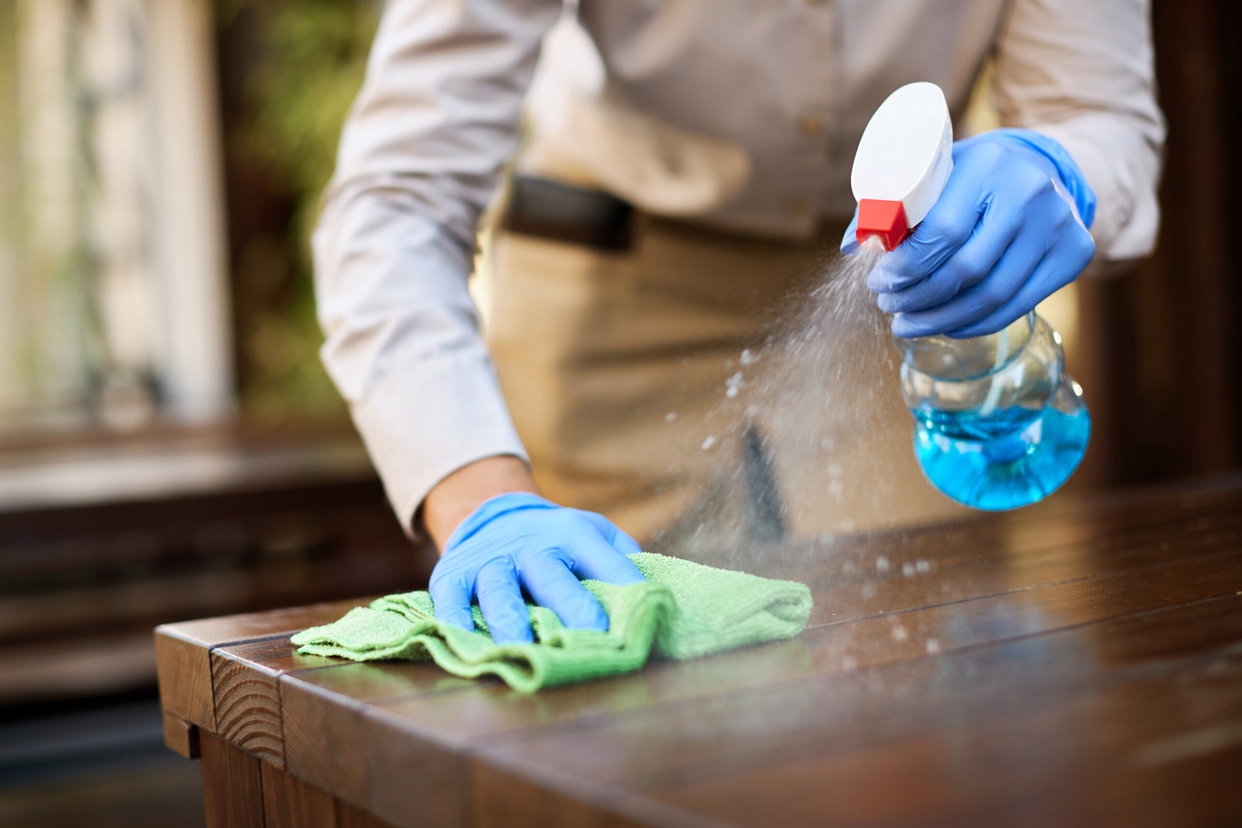 Leistungen close up of waitress disinfecting tables at outdoor cafe.